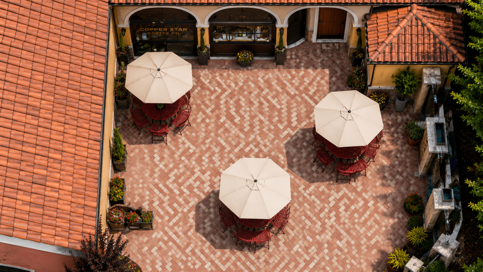 Overhead view of the Copper Star patio with cream umbrellas and wrought iron bistro tables